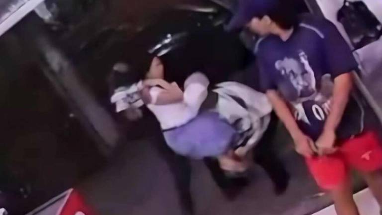Imagen que muestra el momento en el que la mujer es secuestrada frente a una tienda.
