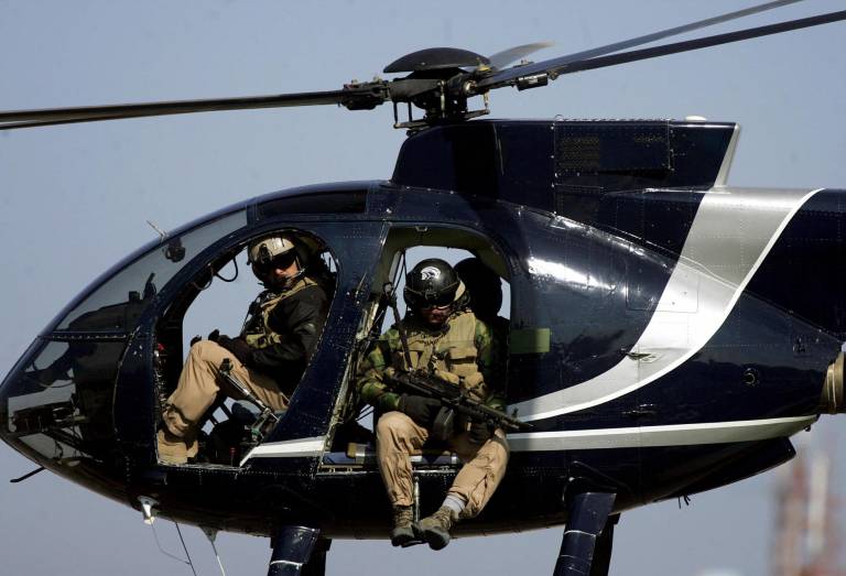 $!Miembros de la empresa de seguridad estadounidense Blackwater inspeccionan el centro de la ciudad de Bagdad desde su helicóptero el 5 de febrero de 2005.