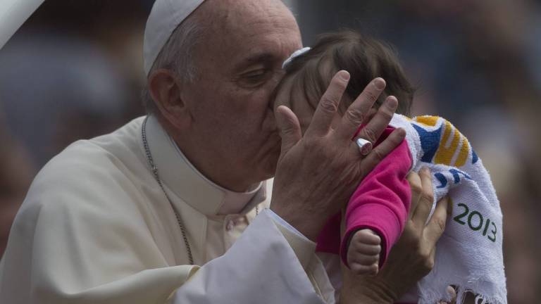 El papa Francisco saluda a una bebé a su llegada al la plaza San Joaquín en Río de Janeiro