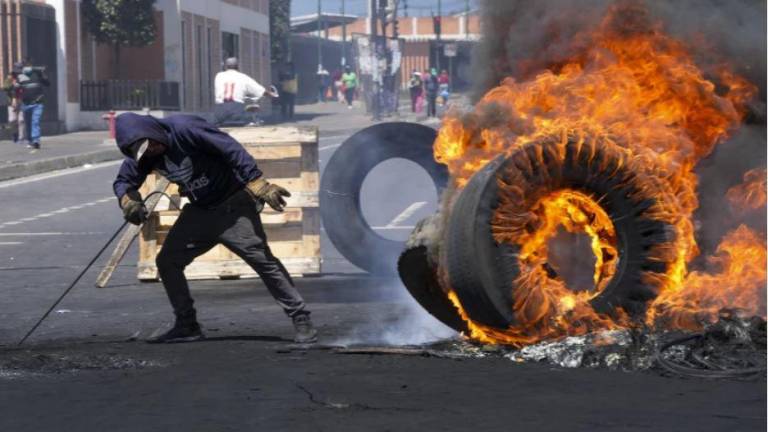 Un hombre quema llantas durante una marcha contra el gobierno de Guillermo Lasso convocada principalmente por organizaciones indígenas, en Quito, Ecuador, el jueves 16 de junio de 2022.