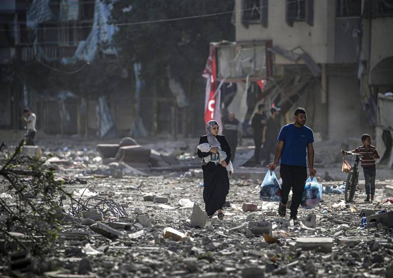 $!Familia palestina camina entre los escombros después de los ataques aéreos israelíes en el barrio de Tel al-Hawa, en la ciudad de Gaza.