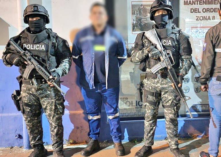 $!Fotografía de uno de los detenidos siendo custodiado por agentes policiales.