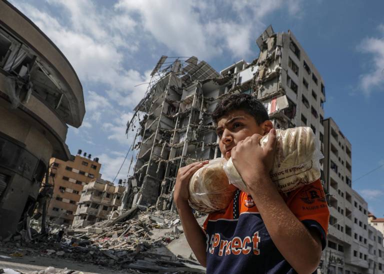 $!Ciudadano palestino se moviliza con raciones de comida a través de la zona de ataques aéreos.