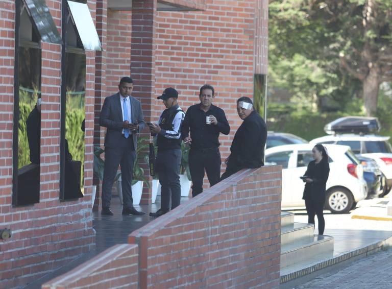 $!Asistentes al sepelio, entre ellos aparentemente uno que habría quedado herido por el atentado en contra del candidato, conversando entre sí.