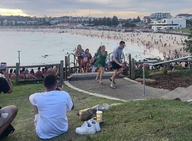 $!Bañistas huyendo de Bondi Beach después de que hombres armados abrieran fuego en Sídney.