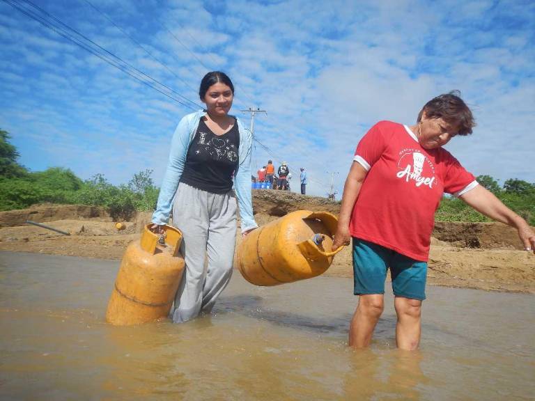 $!Los habitantes de Puerto Engabao tuvieron que hacer trasbordos y cruzaban el río Shusuña a pie con tanques de gas.