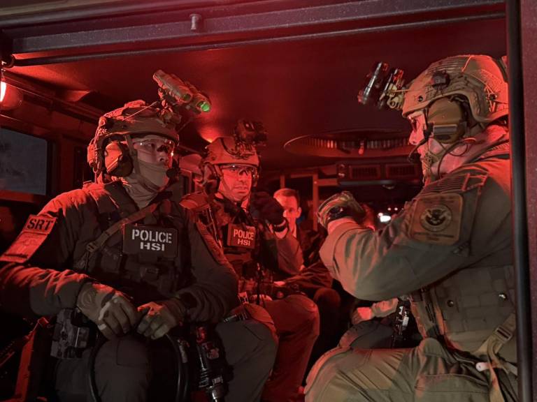 $!Fotografía en la que aparecen unos agentes armados dentro de una camioneta, durante el inicio de una redada contra indocumentados.