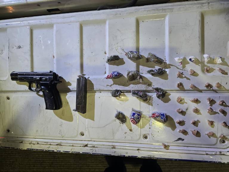 $!El arma que portaba el sujeto abatido, junto a múltiples dosis de droga.