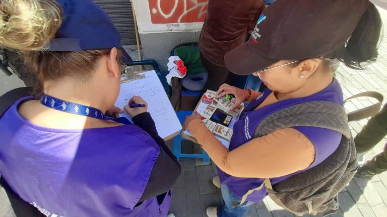 Funcionarias inspeccionan la legalidad de unos cigarrillos.