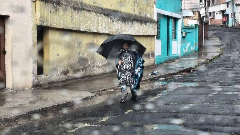 Una persona caminado en la lluvia con su paraguas.