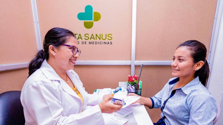 Personal de Vita Sanus entregando medicina a beneficiaria.