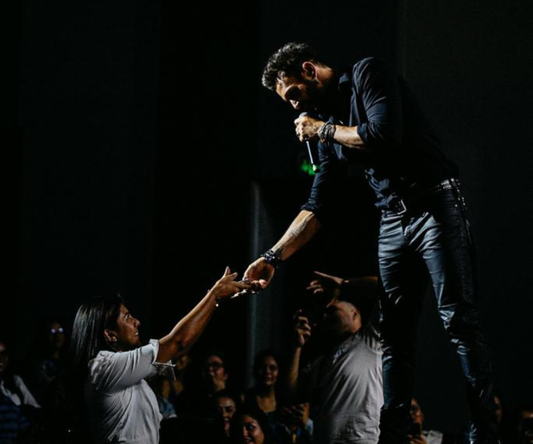 $!Interacción del artista con una fanática, en la que ambos esbozan una sonrisa.