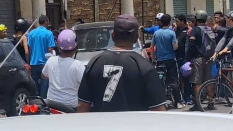 Fotografía de ciudadanos aglomerados alrededor del vehículo en el que encontraba el cuerpo del letrado.