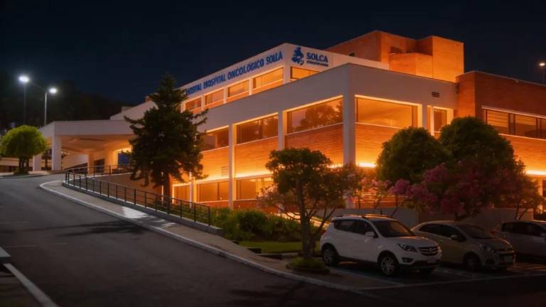 Exteriores de Solca Quito, iluminados de naranja.