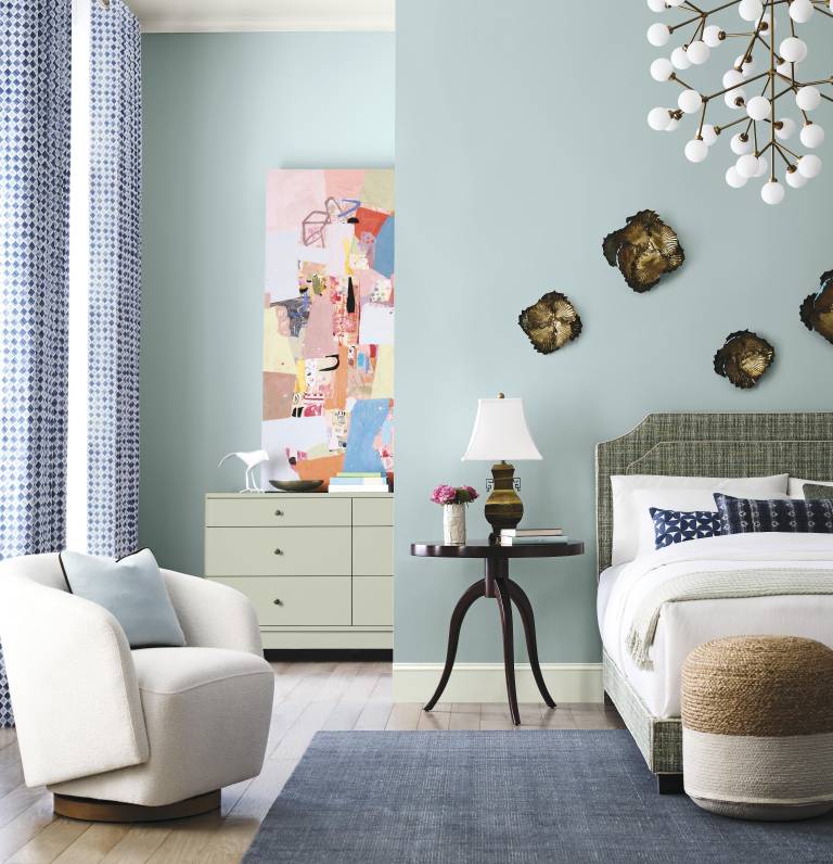 $!Dormitorio luminoso decorado en tonos verde claro y acentos azules, que combina una cama tapizada con textiles texturizados, y un sillón curvo de líneas modernas.