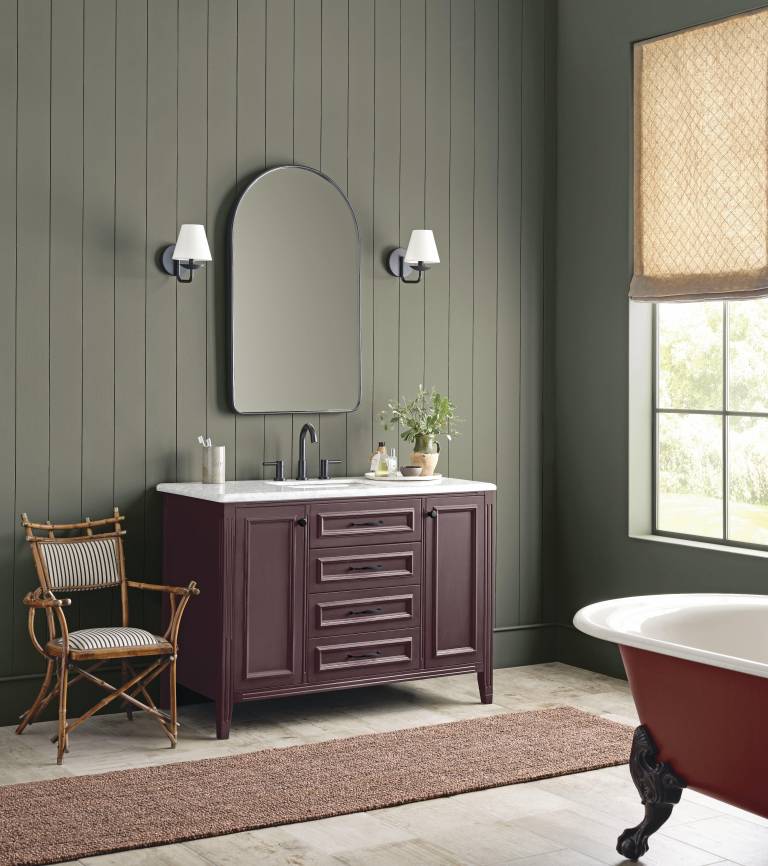 $!Cuarto de baño elegante con paredes revestidas en madera vertical de tono verde oliva, y un tocador clásico en tono vino con encimera de mármol.