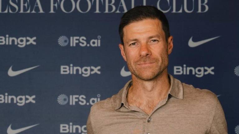 Xabi Alonso junto a la nueva camiseta del Chelsea.