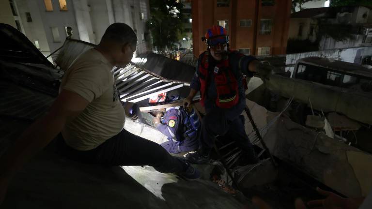 Integrantes del Cuerpo de Bomberos rescatan a una persona este miércoles, en Caracas.