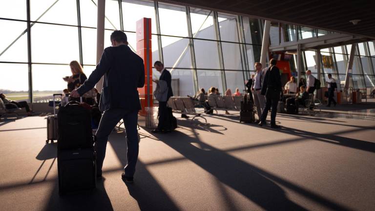 Imagen de referencia de varias personas esperando en un aeropuerto.