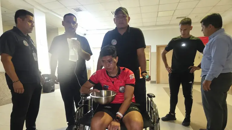 El juez de línea Lenin Ojeda recibiendo atención médica.