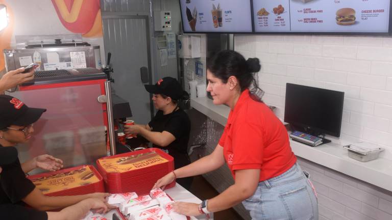 Personal de la cadena de hot dogs Wienerschnitzel atiende en su primer local de Guayaquil.