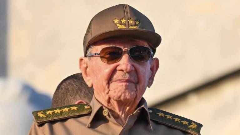 El expresidente cubano Raúl Castro sostiene una bandera cubana durante la conmemoración del Primero de Mayo (Día del Trabajo).