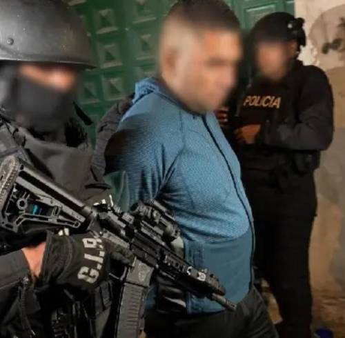 Fotografía que muestra a alias Gordo Arturo bajo custodia de agentes policiales.