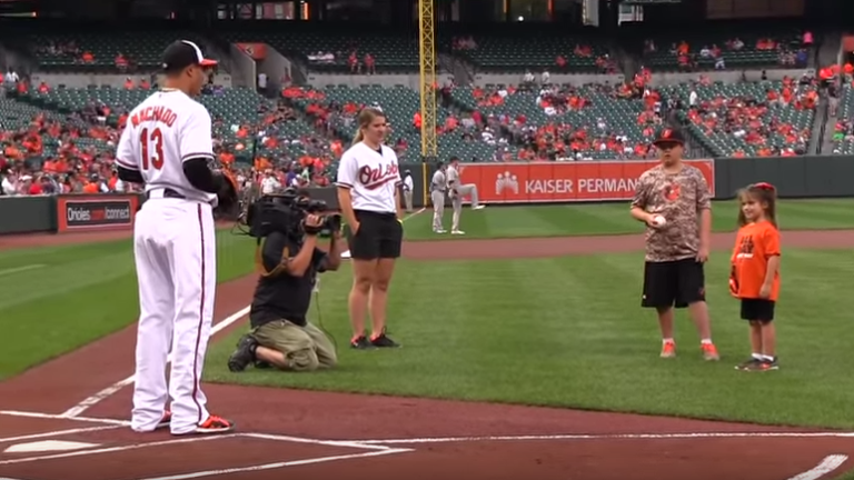 Una niña realiza un lanzamiento de béisbol con su mano robótica