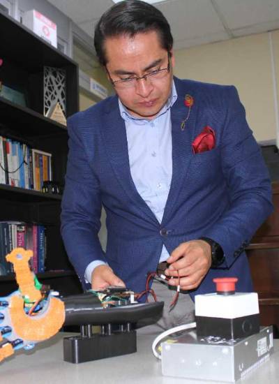 Marco Benalcázar, director del laboratorio de Investigación en IA de la Escuela Politécnica Nacional prueba una prótesis de mano.