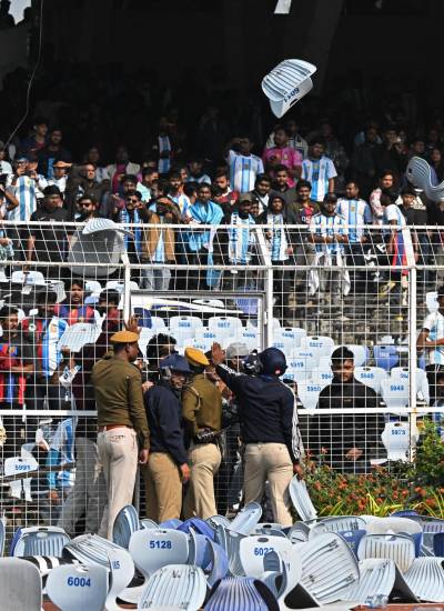 Los aficionados lanzan sillas mientras el delantero argentino número 10 del Inter de Miami, Lionel Messi, sale del Estadio Salt Lake en Calcuta.