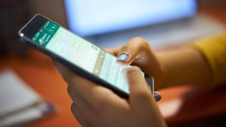Mujer usando la aplicación de mensajería instantánea WhatsApp.