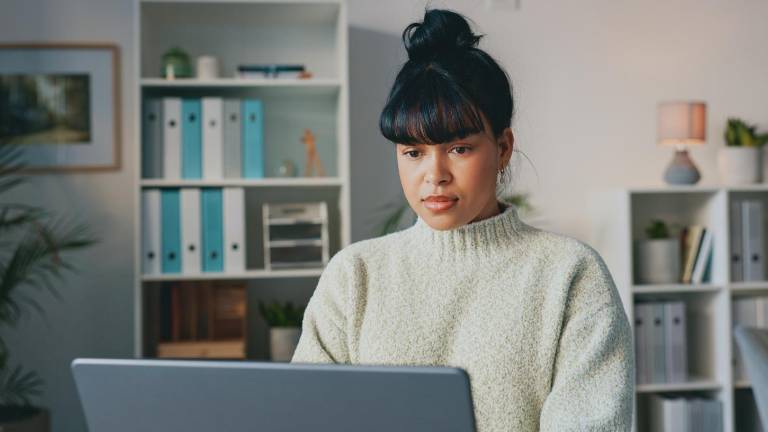 Mujer trabajando en su laptop. Si el correo de Gmail se llena puedes tener opciones para liberar espacio de forma gratuita.