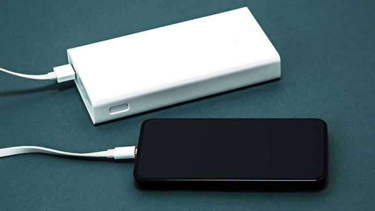 Imagen de un celular siendo cargado con una bateria portátil o power band.