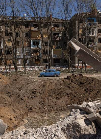 Un automóvil pasa junto a un cráter y un edificio de apartamentos dañado en Kramatorsk, región de Donetsk, Ucrania.