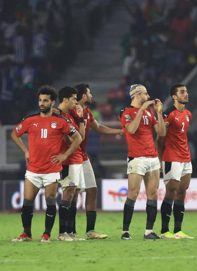 El delantero egipcio Mohamed Salah y el equipo egipcio observan durante la tanda de penaltis en el partido final de fútbol de la Copa Africana de Naciones (CAN) 2021.