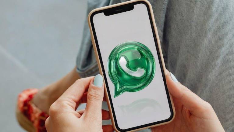 Composición de imagen de una persona con un celular y el icono de WhatsApp modificado.