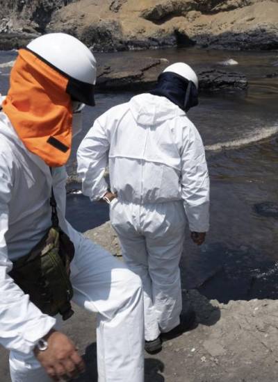Cuadrillas de limpieza laboran para retirar petróleo de una playa en la provincia peruana del Callao.