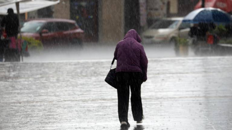 Fotografía de un señor caminando bajo la lluvia en Cuenca, Ecuador.