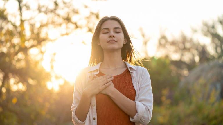 Mujer meditando al aire libre.