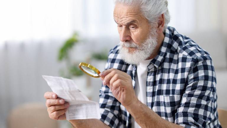 Adulto mayor revisando documentos.