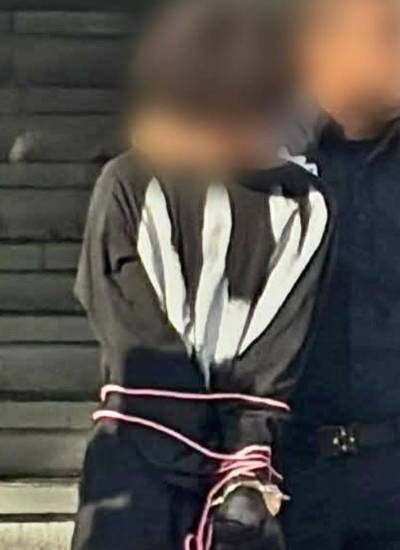 Fotografía que muestra a Omar ‘N’, de 15 años, detenido por un agente de seguridad.
