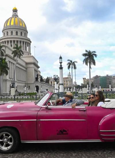 Turistas viajan en un antiguo automóvil estadounidense utilizado como taxi en La Habana.
