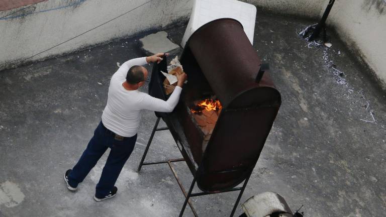 Un hombre quema documetos en el techo de la sede diplomática, la tarde de este miércoles.