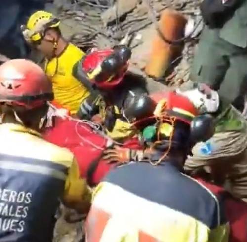 Captura de video que muestra a los bomberos trasladando el cuerpo del menor.