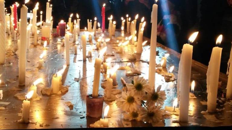 Silencio, flores y velas en el homenaje a los fallecidos