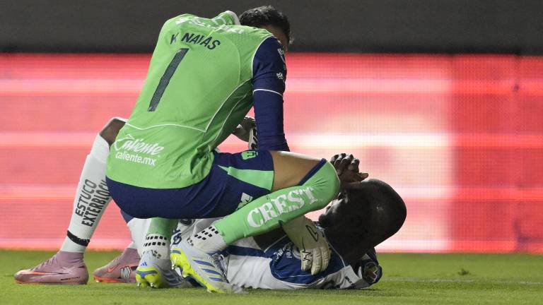 El portero costarricense de Pumas #01 Keylor Navas ayuda al delantero ecuatoriano de Pachuca #10 Enner Valencia durante la semifinal del Clausura de la Liga MX.