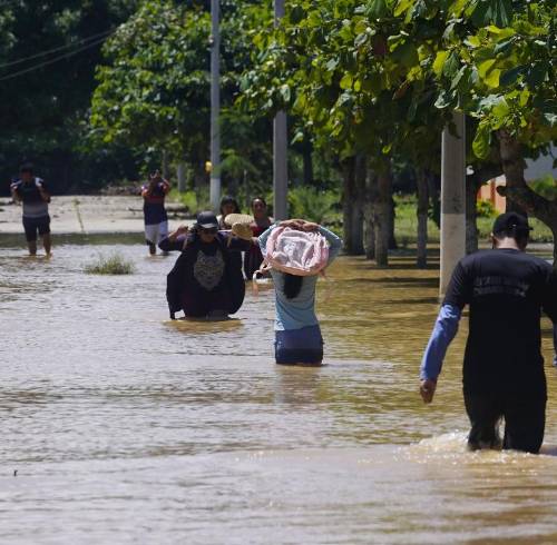 Personas caminan por calles anegadas en Balao el 28 de septiembre.