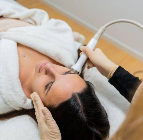 Mujer durante tratamiento estético facial en cabina.