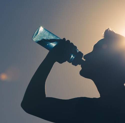 Persona hidratándose por el calor y humedad en Guayaquil.