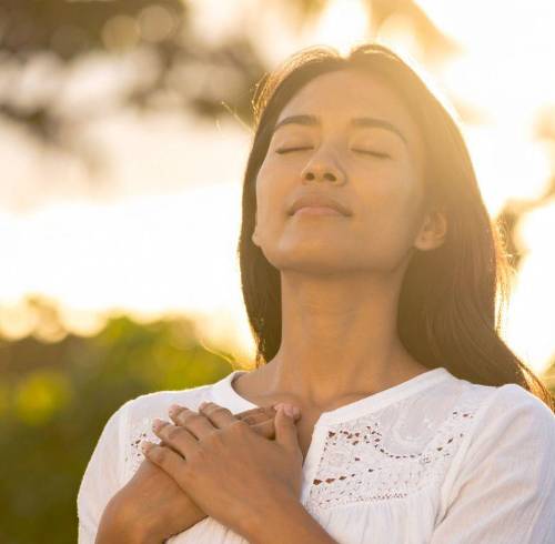 Mujer respirando profundamente en el aire libre.